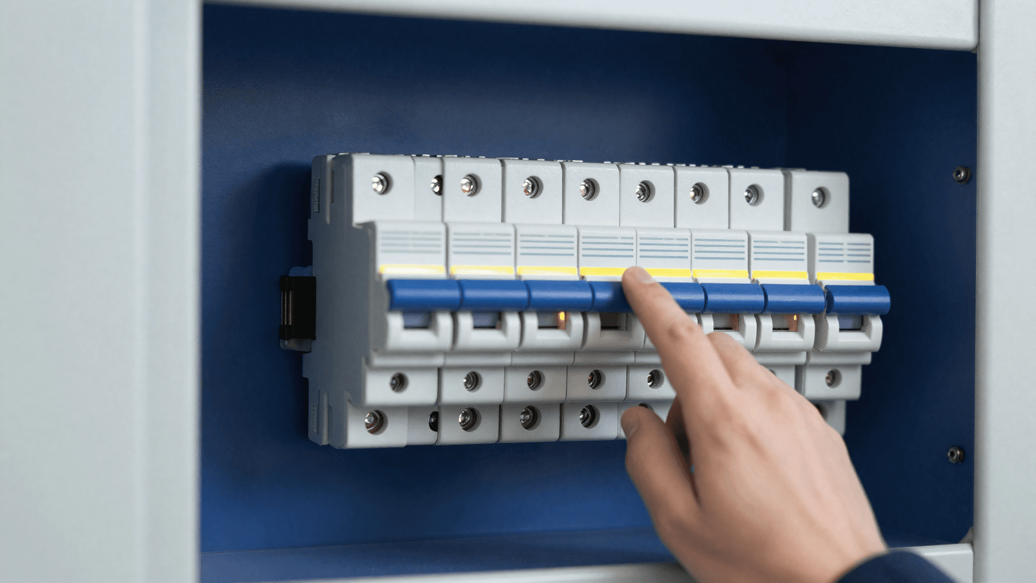 Hand resetting a switch on a modern residential electrical breaker panel